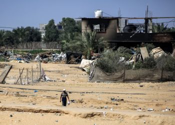 A man walks near a building damaged during Israeli bombardment in Rafah, on the southern Gaza Strip on June 29, 2024. (Photo by Eyad Baba / AFP)