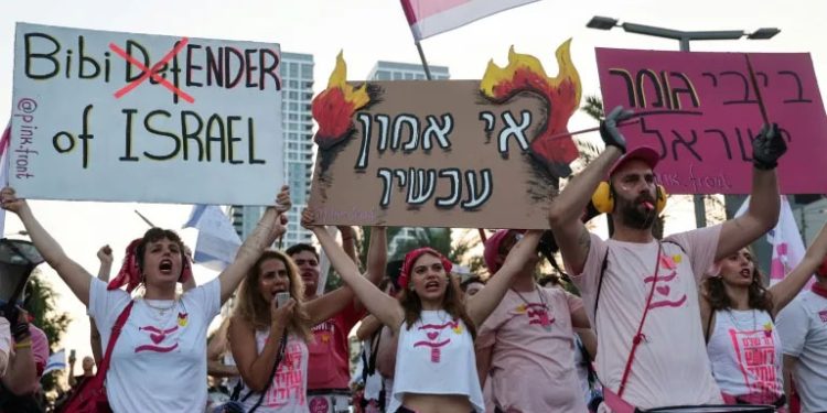 Waving flags, tens of thousands rally against Israeli govt