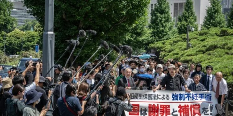Lawyers and supporters of victims of forced sterilisation under a now-defunct eugenics law, carrying a banner demanding apologies and compensations, march toward the Supreme Court of Japan in Tokyo (Yuichi YAMAZAKI)/AFP