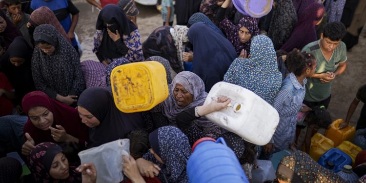 Palestinians displaced by the Israeli bombardment of the Gaza Strip queue for water at a makeshift tent camp in the southern town of Khan Younis, Monday, July 1, 2024. (AP Photo/Jehad Alshrafi)ASSOCIATED PRESS