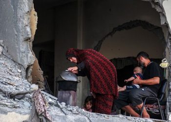 A Palestinian family gathers around a makeshift wood stove in a damaged building in Khan Yunis, southern Gaza © Bashar TALEB / AFP