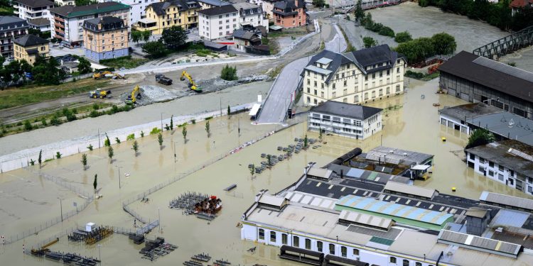 The Rhone in Chippis, Switzerland, overflowed due to ferocious storms and torrential rains, leading to flooding of a highway and a railway line close by. Photograph: Jean-Christophe Bott/AP