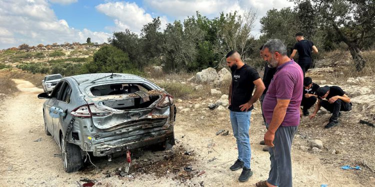 Palestinians assess the damage of a car during a military operation by Israeli forces near Jenin in the Israeli-occupied West Bank August 28, 2024. REUTERS/Ali Sawafta