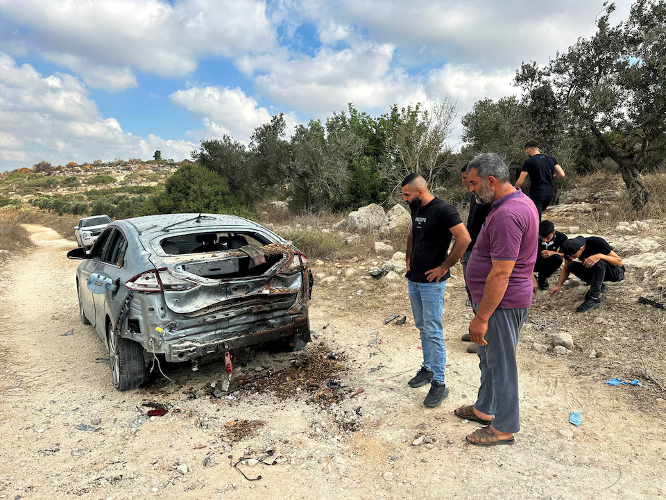 Palestinians assess the damage of a car during a military operation by Israeli forces near Jenin in the Israeli-occupied West Bank August 28, 2024. REUTERS/Ali Sawafta