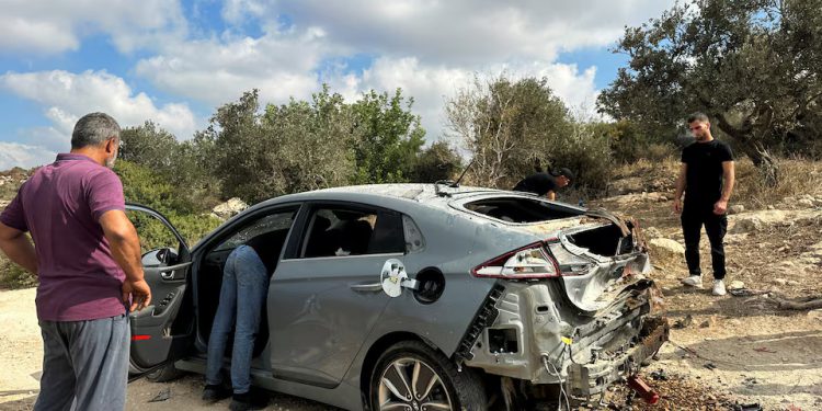 Palestinians assess the damage of a car during a military operation by Israeli forces near Jenin in the Israeli-occupied West Bank August 28, 2024. REUTERS/Ali Sawafta