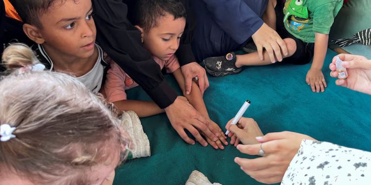 Palestinians gather during a polio vaccination campaign, amid the Israel-Hamas conflict, in Deir Al-Balah in the central Gaza Strip, September 1, 2024. REUTERS/Hussam Al-Masri