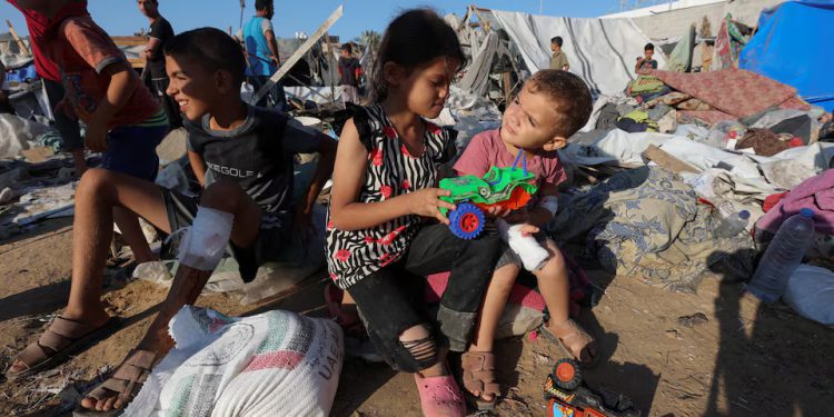 Palestinian children sit at the site of an Israeli strike on the courtyard of Al-Aqsa Martyrs hospital, where displaced people were taking shelter in tents, amid the Israel-Hamas conflict, in Deir Al-Balah in the central Gaza Strip, September 5, 2024. REUTERS/Ramadan Abed