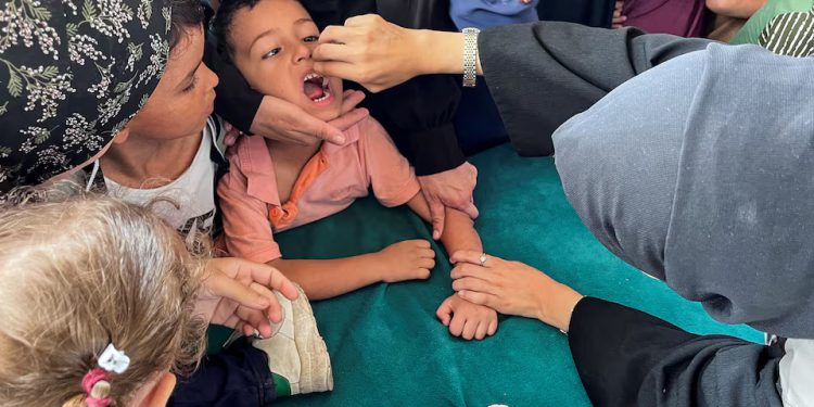A Palestinian child is vaccinated against polio, amid the Israel-Hamas conflict, in Deir Al-Balah in the central Gaza Strip, September 1, 2024. REUTERS/Hussam Al-Masr