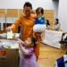 A woman accompanying her children in Halloween costume casts her ballot in the general election at a polling station in Tokyo, Japan October 27, 2024. REUTERS/Kim Kyung-Hoon