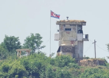 A soldier stands at a North Korean military guard post flying a national flag, seen from Paju, South Korea, on June 26, 2024. (AP Photo/Lee Jin-man, File)
