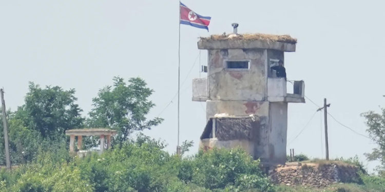 A soldier stands at a North Korean military guard post flying a national flag, seen from Paju, South Korea, on June 26, 2024. (AP Photo/Lee Jin-man, File)
