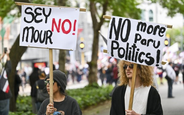 Protesters march carrying placards to New Zealand’s parliament to demonstrate against a proposed law that would redefine the country’s founding agreement between Indigenous Māori and the British Crown, in Wellington, New Zealand, Tuesday, Nov. 19, 2024. (AP Photo/Mark Tantrum)