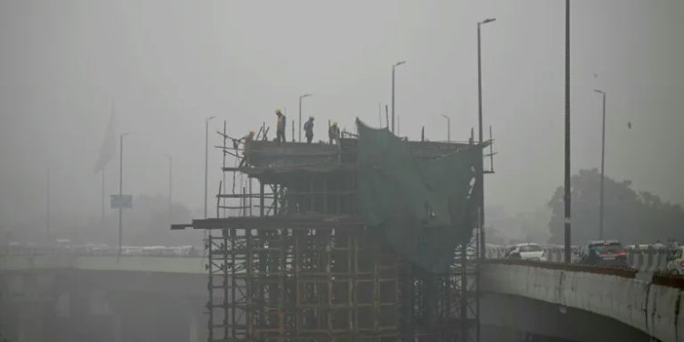 Labourers stand on a scaffolding amid dense smog in New Delhi on November 13, 2024 (Sajjad HUSSAIN) (Sajjad HUSSAIN/AFP/AFP)