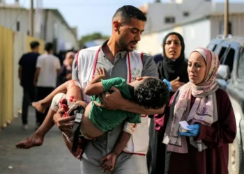 A worker at al-Awda Hospital carries a child who was injured by reported Israeli bombardment on al-Bureij September 21, 2025 (Eyad BABA) Eyad BABA/AFP/AFP