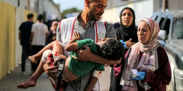 A worker at al-Awda Hospital carries a child who was injured by reported Israeli bombardment on al-Bureij September 21, 2025 (Eyad BABA) Eyad BABA/AFP/AFP