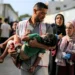 A worker at al-Awda Hospital carries a child who was injured by reported Israeli bombardment on al-Bureij September 21, 2025 (Eyad BABA) Eyad BABA/AFP/AFP